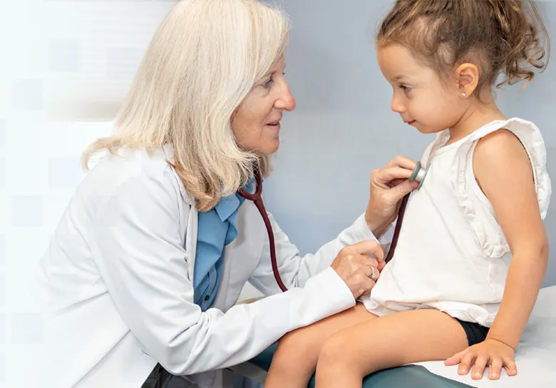 Physician listening to a young girl's heartbeat with a stethoscope during an allergy evaluation