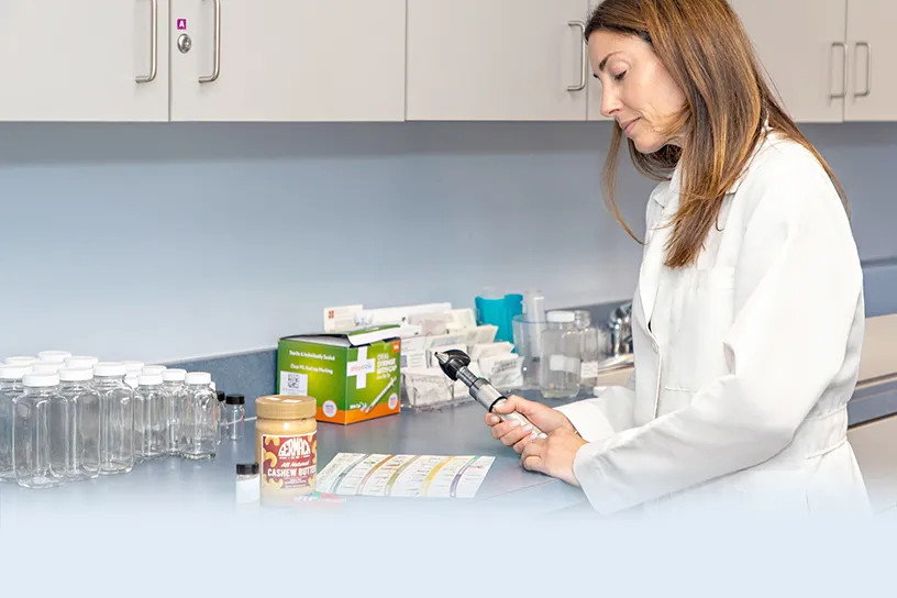 Allergist measuring food doses at a counter lined with labeled jars