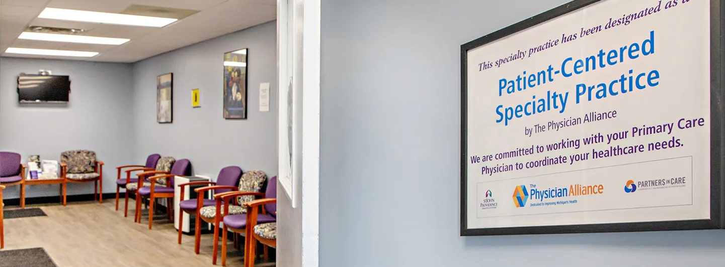 Waiting room with chairs and a framed Patient-Centered Specialty Practice certificate