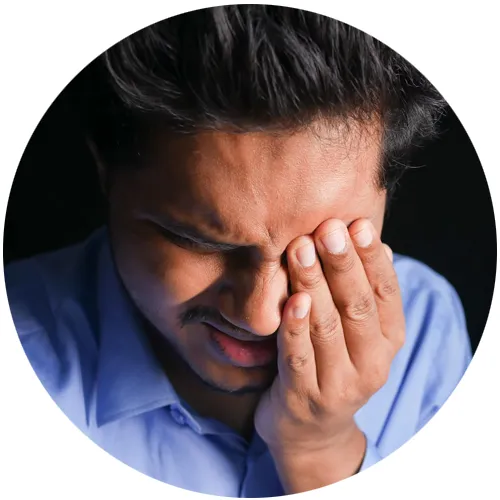 Man pressing his fingers against his eye and sinus in discomfort